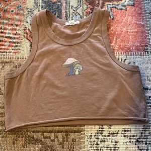 I am selling a full tilt brown crop top that have two mushrooms in the middle.